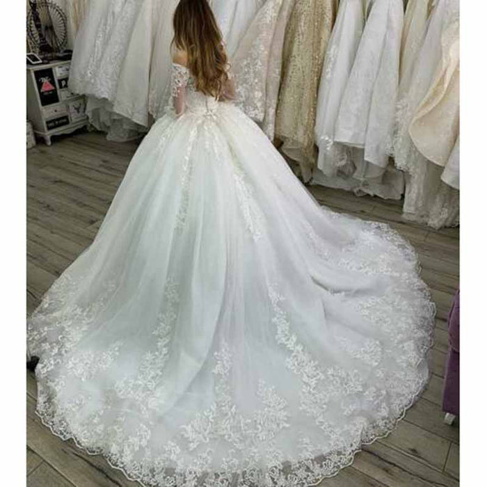 Elegant lace beach wedding dress with sleeves and a flowing train, perfect for outdoor ceremonies