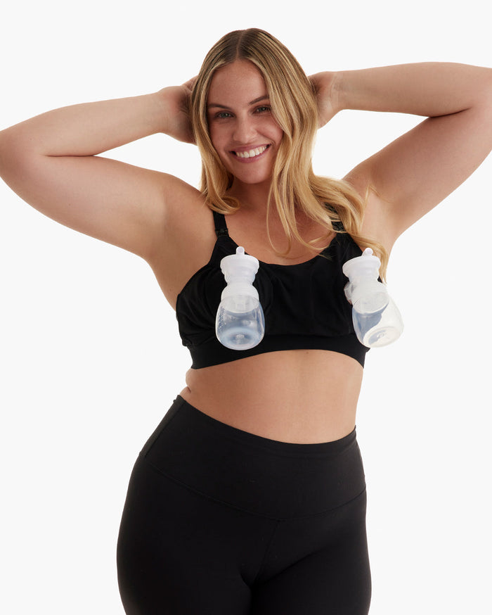 Smiling blonde demonstrates hands-free pumping in black YN08 bra with adjustable straps & wide underband.