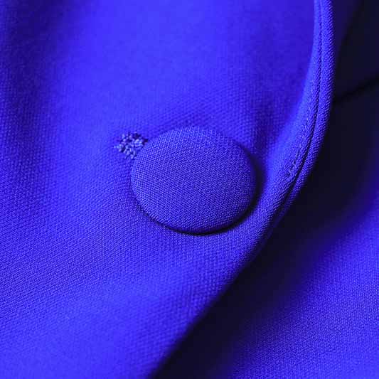 Close-up of a purple fabric featuring a round button for the one button blazer and flare pants set