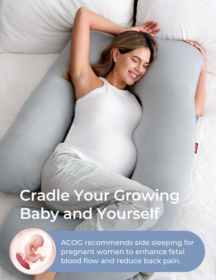 Pregnant woman resting on a gray U-shaped maternity pillow, promoting restful sleep and baby support, Momcozy