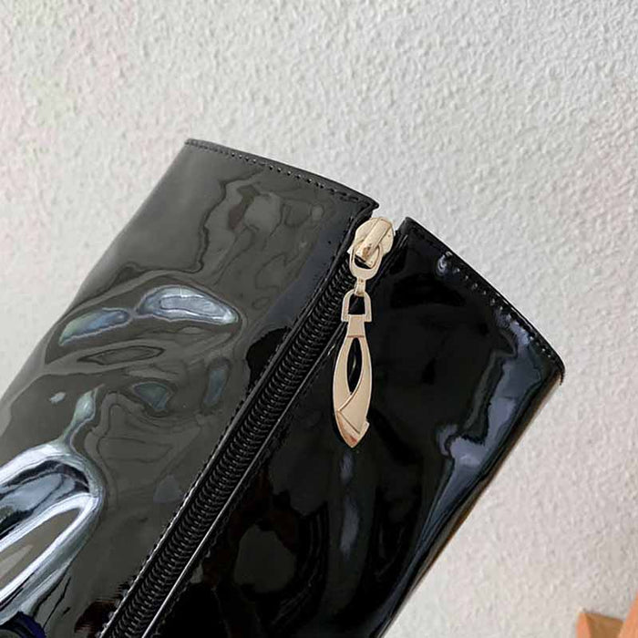 Close-up of glossy black platform high heel boots for women with stylish zipper detail