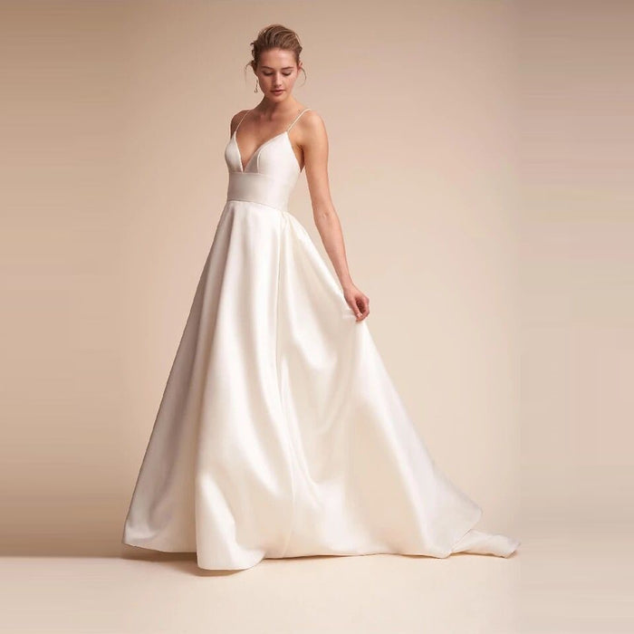 Elegant white slip wedding dress with a flattering deep V-neckline and flowing skirt