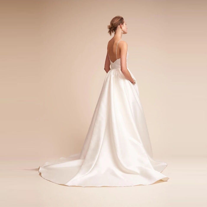 Elegant white slip wedding dress with a flowing train and simple back design