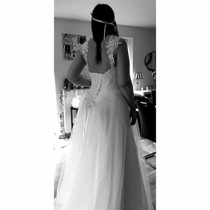 Back view of a simple princess wedding dress with lace detailing and flowing skirt for elegant brides