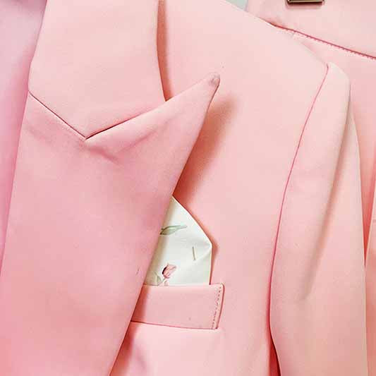 Close-up of a pink blazer pantsuit for women featuring a stylish pocket square and elegant lapels