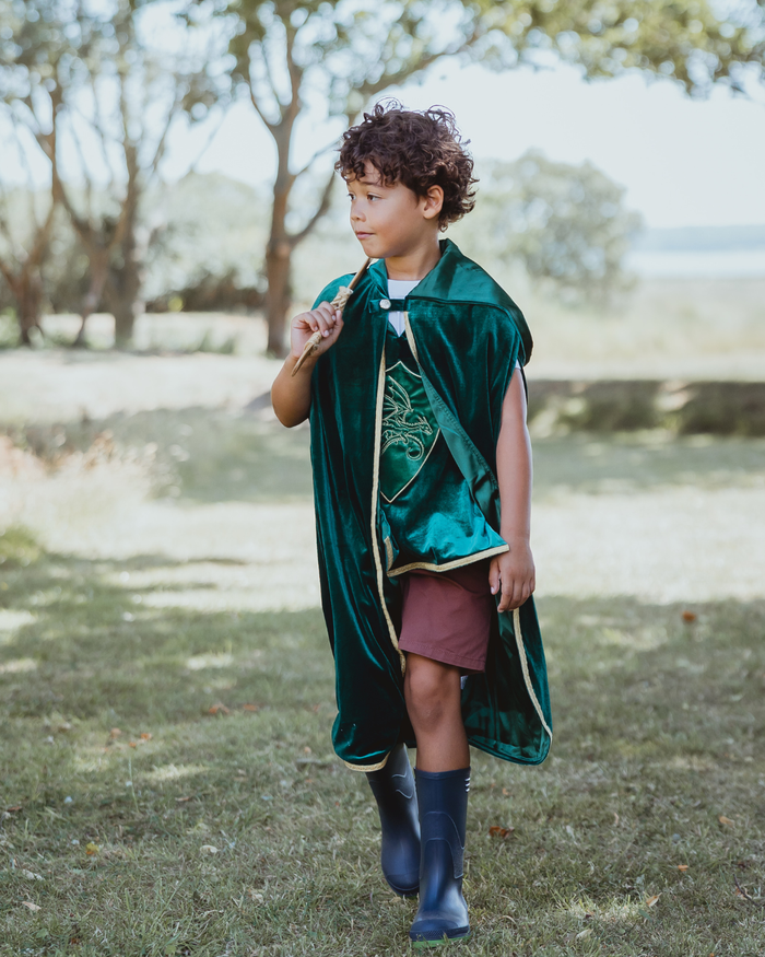 Child wearing a green velvet hooded cape with an oversized hood