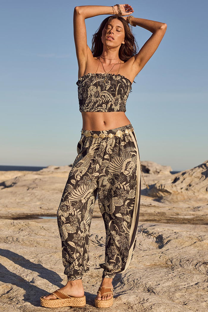 Front view of Volcano Goddess Harem Pant, black tropical print with side stripe and tie hem cuffs
