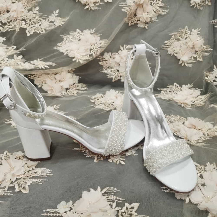 Elegant white high heel wedding shoes with pearl embellishments and a chic design