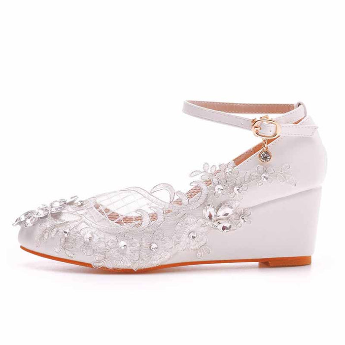 Elegant white wedge bridal sandals with floral lace and embellishments for the perfect wedding look